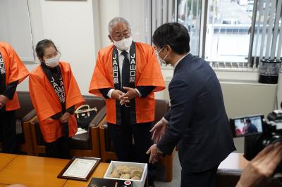 吉武本部長（中央）から嬉しい報告を受ける伊藤市長（右）
