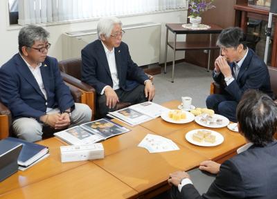 「カーターショコラ」の説明をする藤井公代表取締役社長ら（左）と「カーターショコラ」を味わう市長（右）