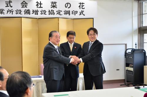 調印式で握手を交わす市長（左）伊藤山口県商工労働部企業立地統括監（中）、宮本久和代表取締役社長（右）