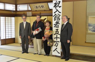 入館者50万人目となった中村友梨美さん（右から2番目）とご主人の義和さん（右から3番目）
