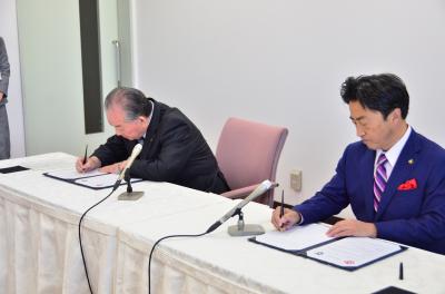 協定書に署名をする渡辺市長（左）と片岡市長（右）