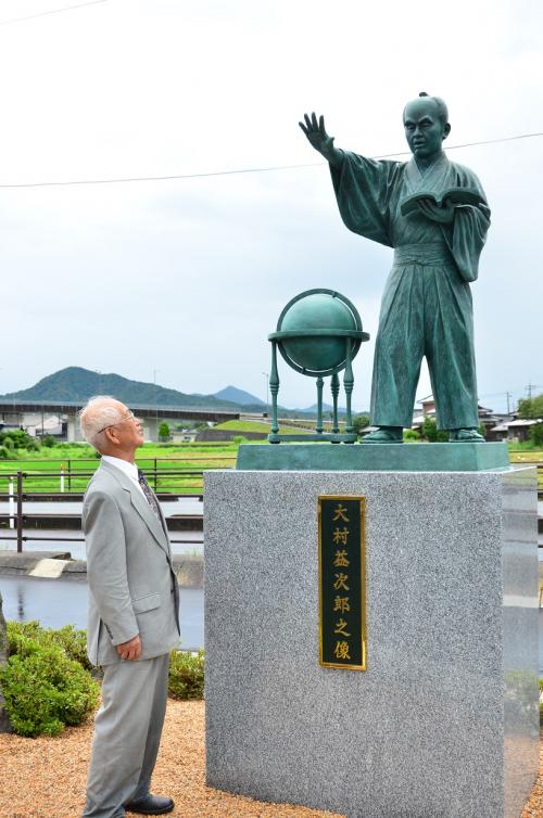 建立された大村益次郎の銅像を前にする岡本会長