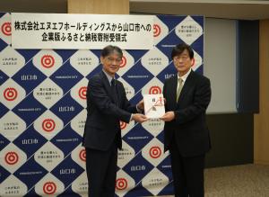 寄附金の目録を受け取る市長