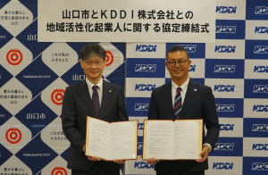 協定書を持つ市長(左)とKDDI株式会社の高木秀悟執行役員(右)