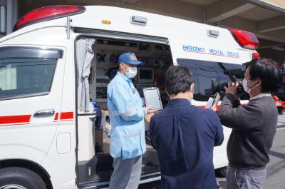 救急車と医療機関を生中継でつなぐためのタブレットを手に仕組みを説明する救急救命士