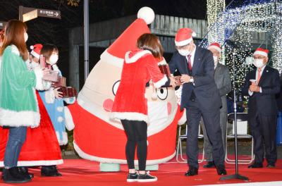 スタンプラリーのスタンプをサンタクロース配達員（中央）に渡す市長（右）