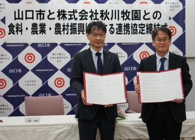 記念撮影の様子（左から、市長、秋川代表取締役社長）