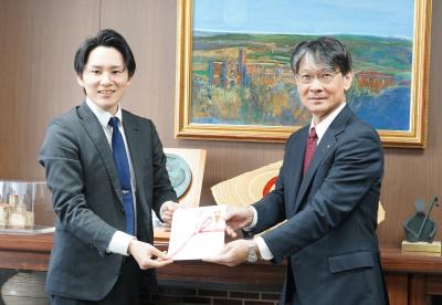東川山口営業所長（左）から寄附金の目録を受け取る市長（右）