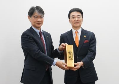 記念品を手渡す市長（左）と王家馴会長（右）