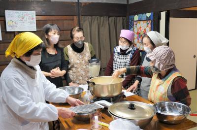 萩市から訪れた方々と地域の皆さんが、交流を深めながら豆腐作りに挑戦する様子
