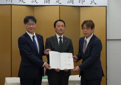 協定書を手にする有限会社エフケイケイ物流の木村代表取締役（右）、山口県の末廣企業立地統括監（中央）、市長（左）