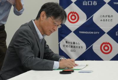 協定書に調印する市長