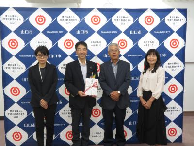 義援金贈呈にあたって記念撮影をしている様子（右から篠目しっちょる会：谷口様、中村代表、日本赤十字社山口市地区：鈴木副地区長、堀参与）