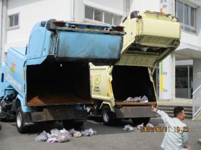 ごみ収集車から中身を下ろして説明している写真