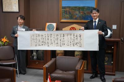 鄒平市から本市に贈られた書を披露する両市長