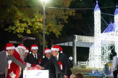 イルミネーションの点灯ボタンを押す市長（写真中央）と式典参加者