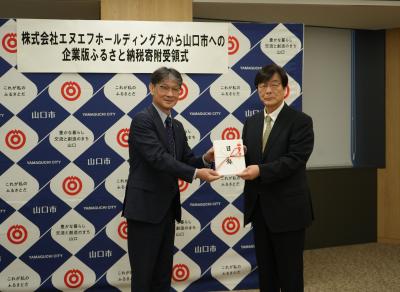 寄附金の目録を受け取る市長