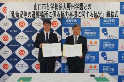 協定書を手にする市長（左）と学校法人野田学園の田邉理事長（右）