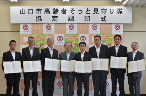 協定書を受け取った業者の皆さんと市長(左から4番目)
