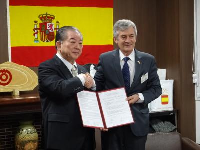 覚書を交わして握手するカルペナ会長と市長