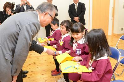 防犯ブザーとランドセルカバーを受け取る園児ら