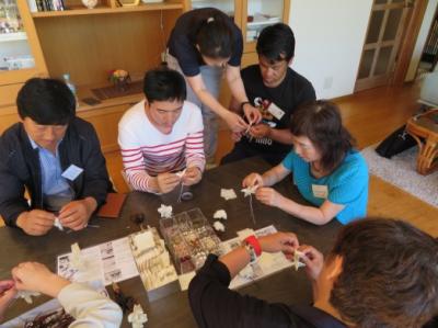 檜皮を使った花飾り作りの体験をされる交流訪問団と山口市民の皆さんの写真