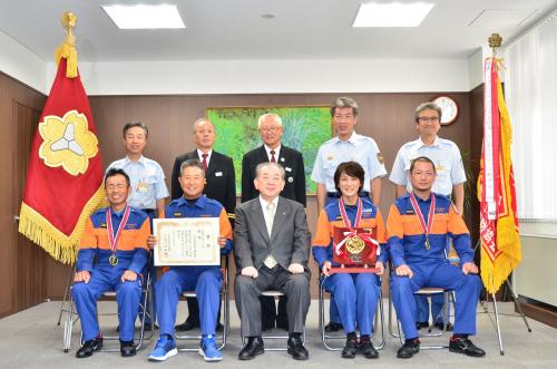 上郷分団と市長、関係者の集合写真（賞状・優勝旗などと共に）