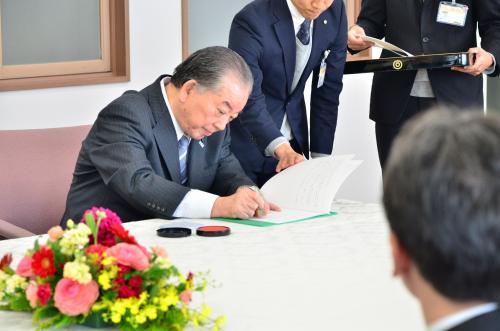 協定書に調印する市長