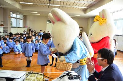 ゆう太くんゆう子ちゃんからステッカーをもらう園児