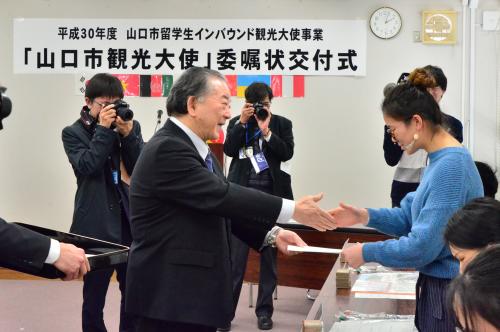 一人ひとりに委嘱状を交付し握手する市長