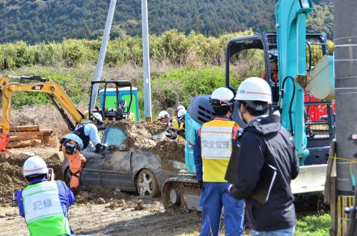 土砂に埋もれた車を引き出している様子