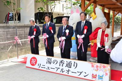 新設した足湯の前でテープカットをする式典出席者