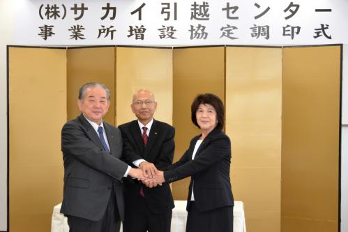 調印式で握手を交わす市長（左）、坂田山口県商工労働部企業立地統括監（中）、中野秋代専務取締役（右）
