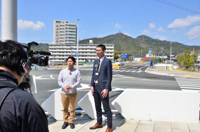 3月に開通した都市計画道路「新山口駅長谷線」の紹介をするリポーターと市職員