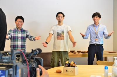 第7回アーティスト大賞の竹部徳真さん（中央）と一緒に、応募を呼びかけるレポーターと市職員
