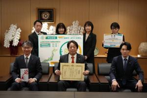 記念撮影（前列左から、市長、北島支社長、東川純也山口営業所長。後列左から、橋本泰樹小郡営業所長、鈴木薫山口西京営業所長、黄加津恵山口営業所総務課長、健康福祉部長